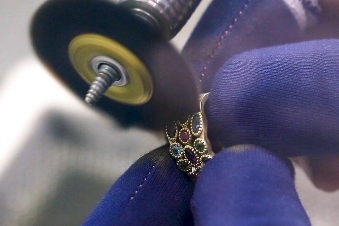 A stone-set ring being polished in the workshop